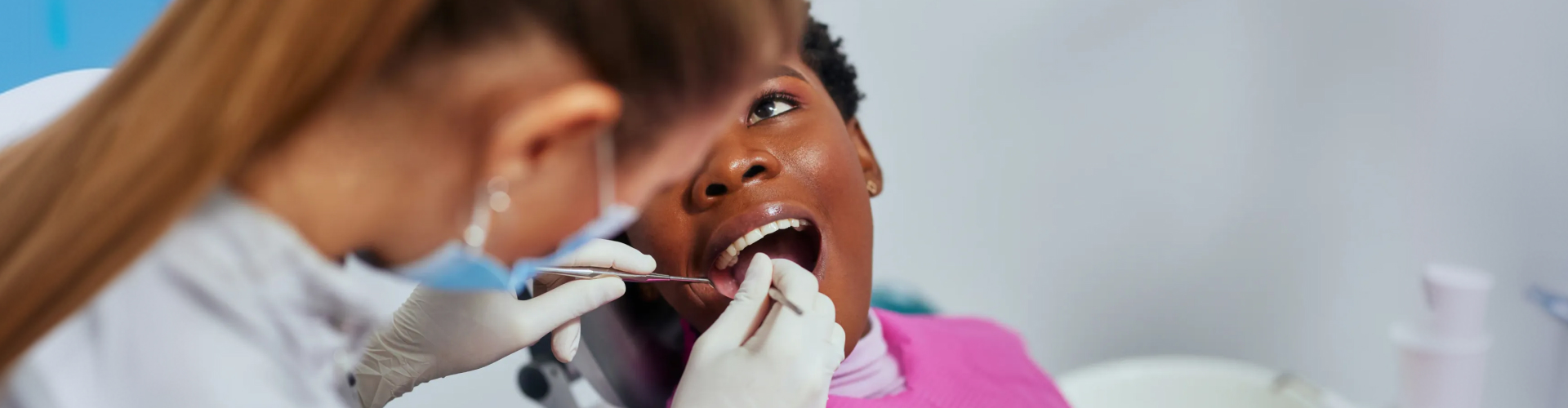 Dental professional performing an oral examination and cleaning on a patient.